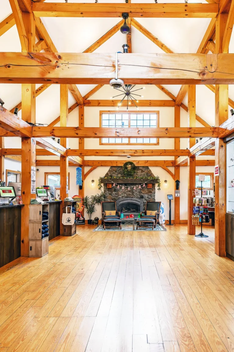 Timber-frame interior of Bud Barn with a stone fireplace